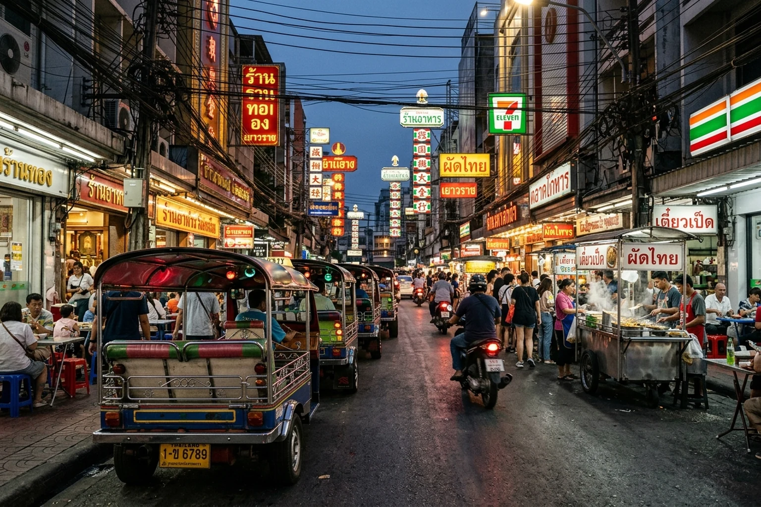 Tuk-tuks and neon signs on a busy Bangkok street at dusk
